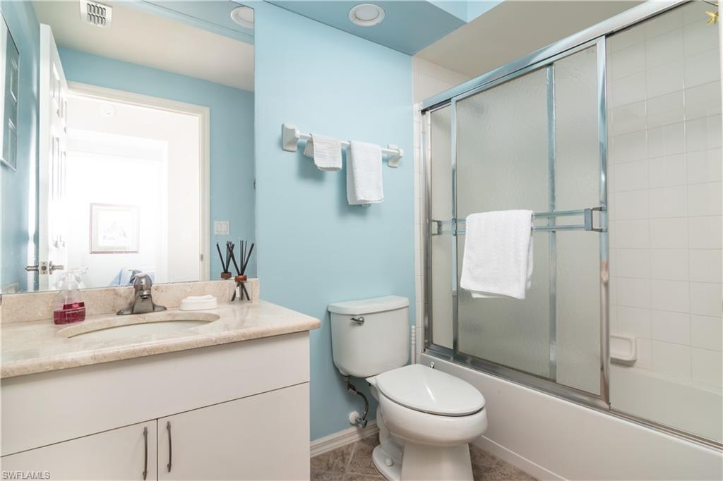 2585 Old Groves Road, Unit L102 Naples, FL 34109 - Photo 12 of 29 a bathroom with a granite countertop sink toilet and shower