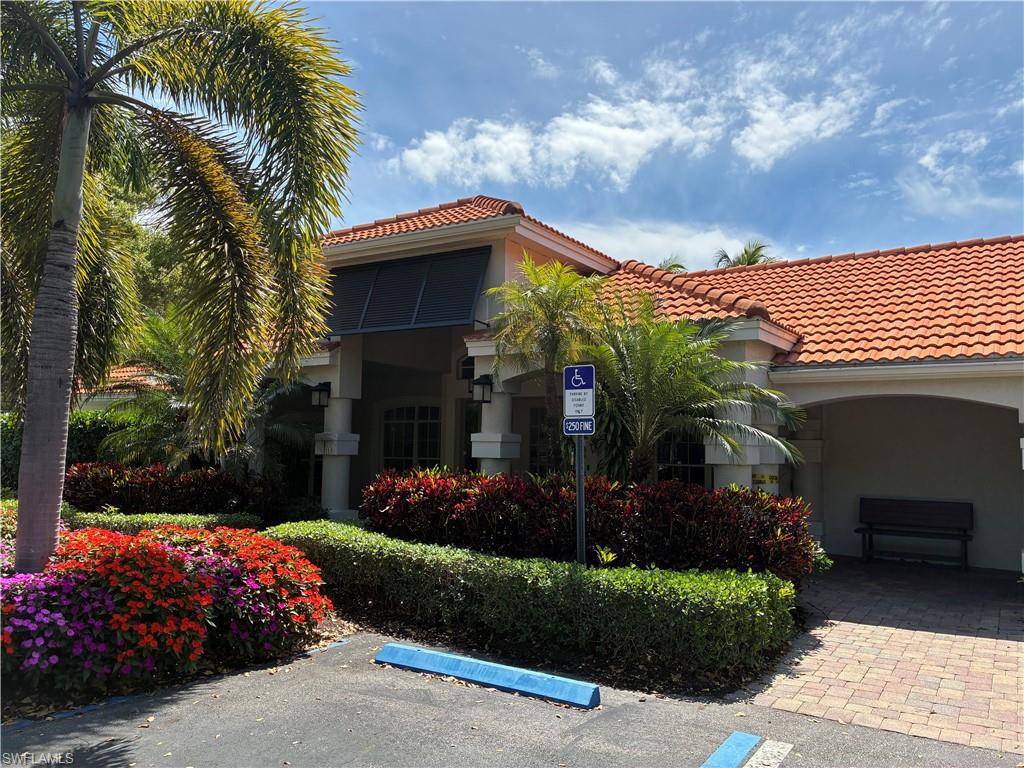 2585 Old Groves Road, Unit L102 Naples, FL 34109 - Photo 23 of 29 a front view of a house with a yard and potted plants