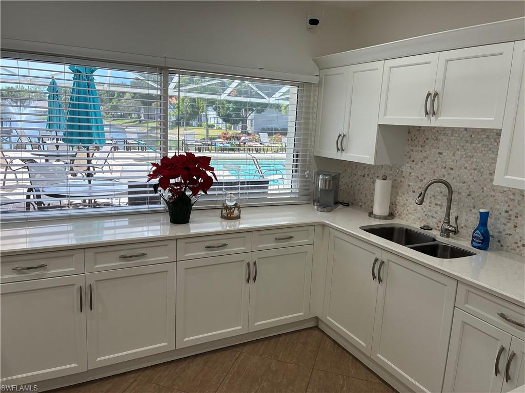 2585 Old Groves Road, Unit L102 Naples, FL 34109 - Photo 24 of 29 a kitchen with a sink cabinets and a large window