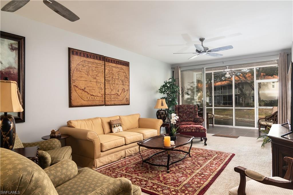 2585 Old Groves Road, Unit L102 Naples, FL 34109 - Photo 3 of 29 a living room with furniture a rug and a large window