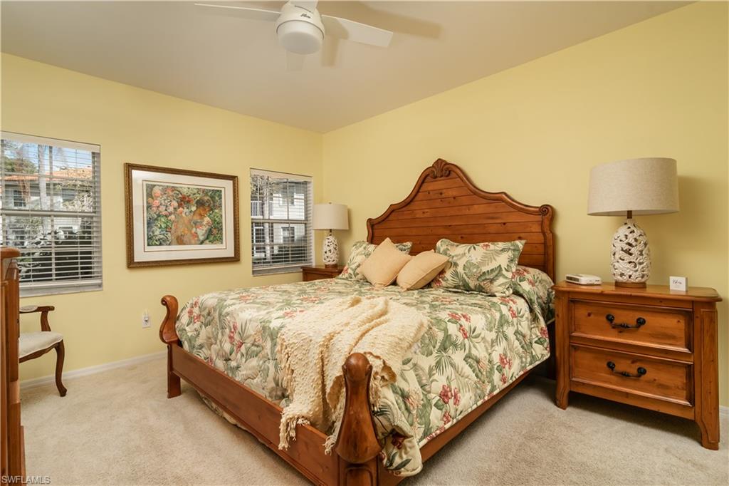 2585 Old Groves Road, Unit L102 Naples, FL 34109 - Photo 8 of 29 a bedroom with a bed and a night stand