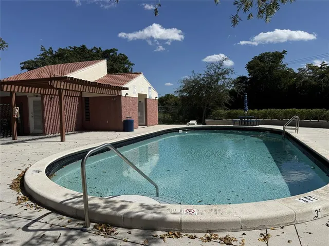 a view of a swimming pool with a yard and plants