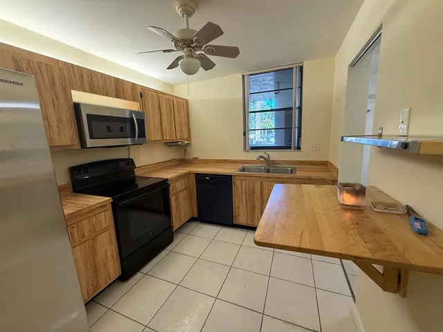 a kitchen with a sink a stove top oven and cabinetry