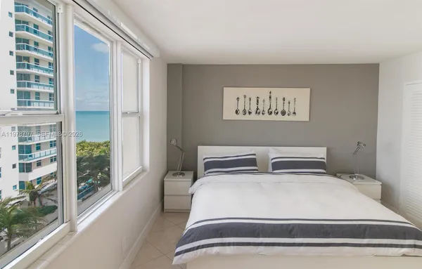 a bedroom with a bed and a large window with outer view