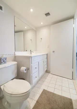 a bathroom with a sink a toilet and mirror