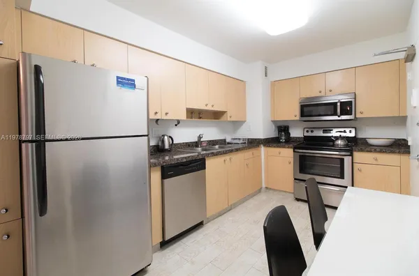 a kitchen with stainless steel appliances a refrigerator stove microwave and sink