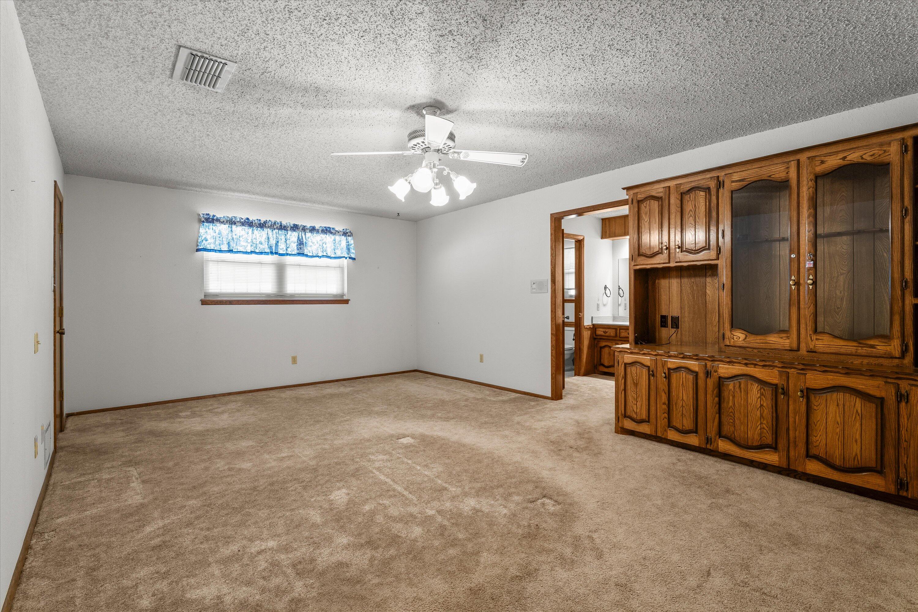 308 West 6th Street Sundown, TX 79372 - Photo 14 of 33 an empty room with chandelier fan and windows