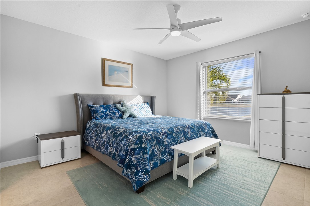 6187 Red Maple Manor Vero Beach, FL 32966 - Photo 14 of 31 a bedroom with a bed and a chandelier