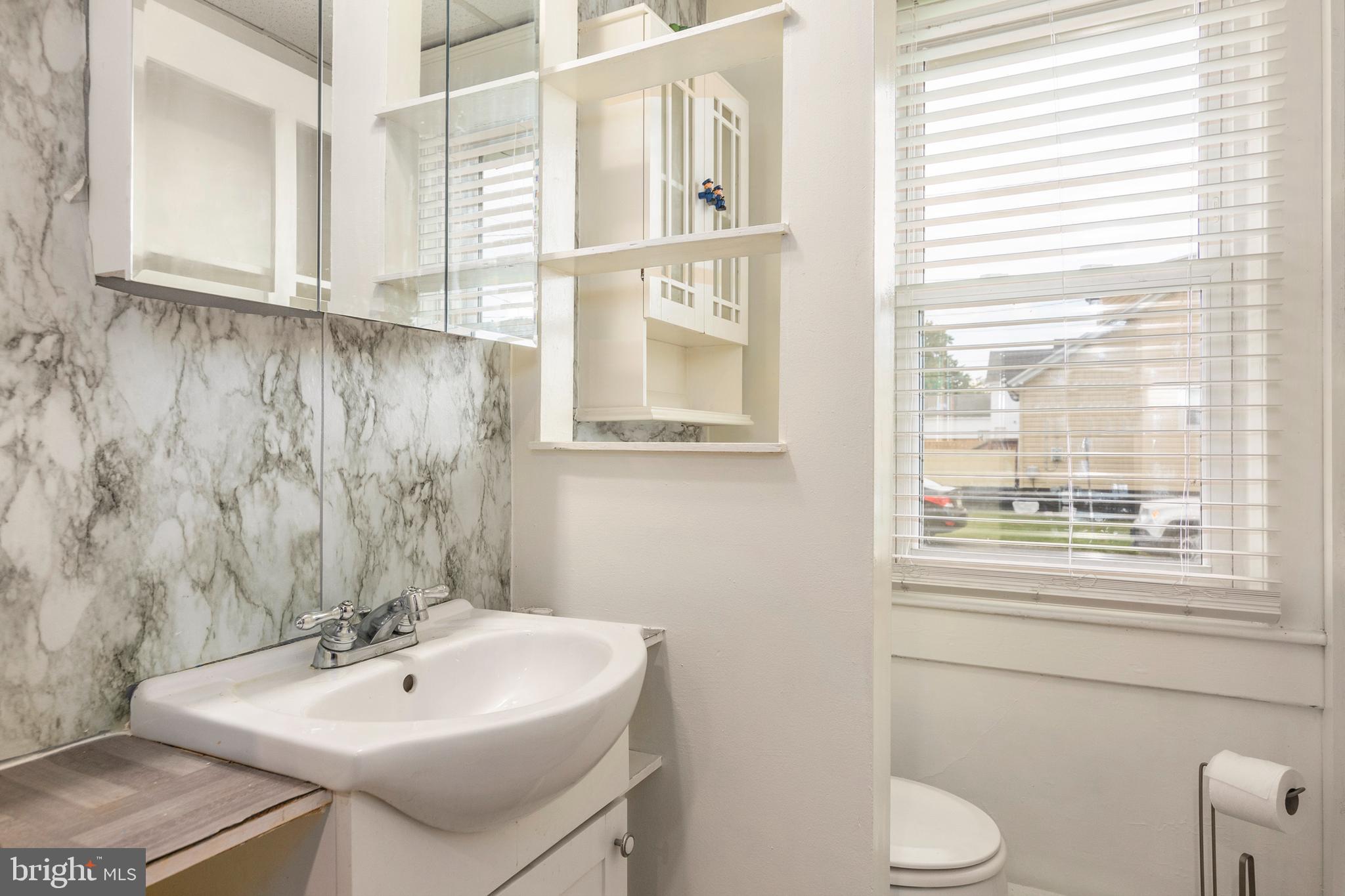 201 Washington Street Cambridge, MD 21613 - Photo 16 of 31 a bathroom with a sink a toilet and a bathtub