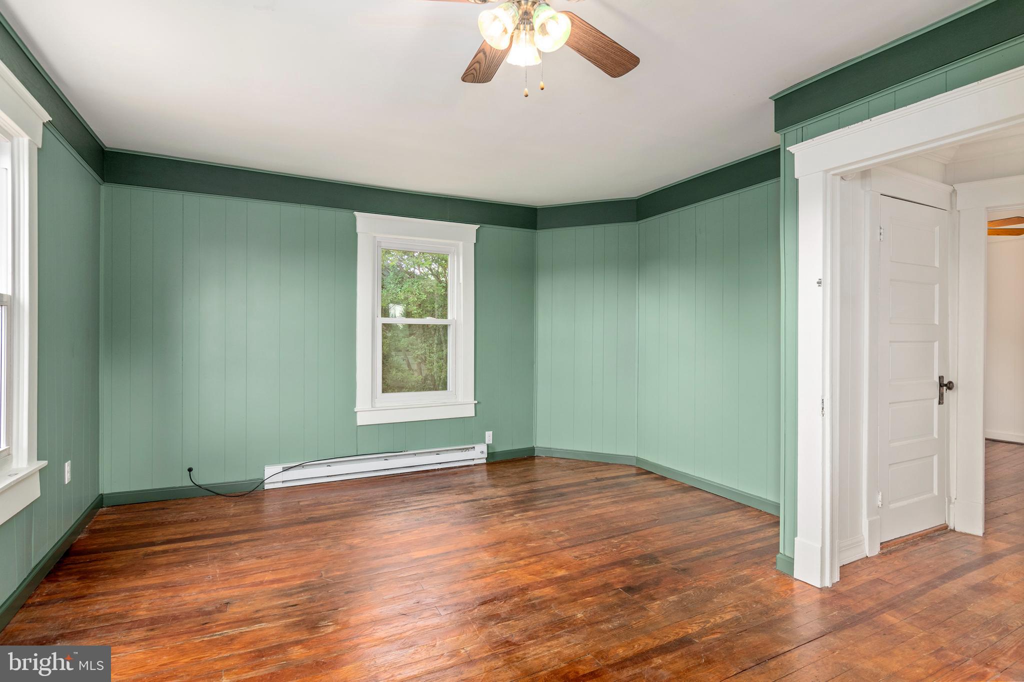 201 Washington Street Cambridge, MD 21613 - Photo 20 of 31 an empty room with wooden floor chandelier and windows