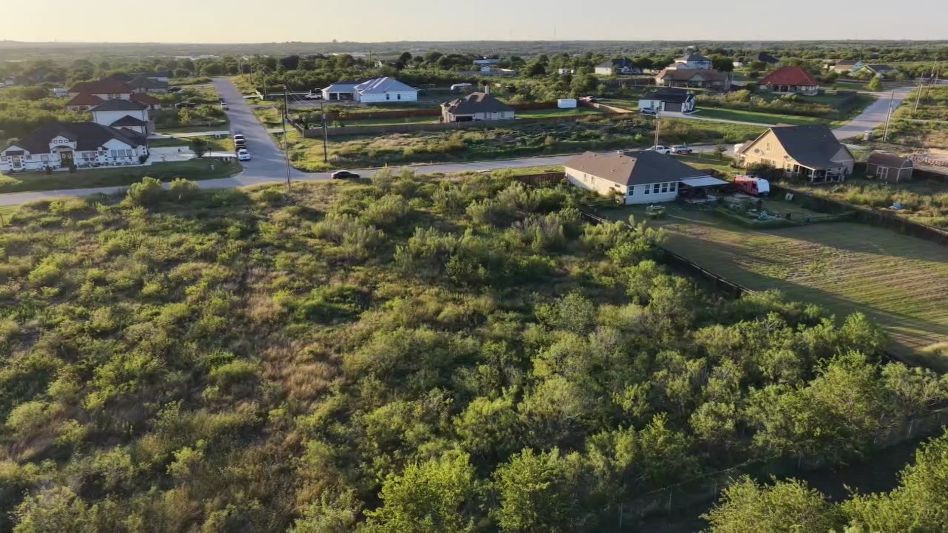 232 East Ridge Lane Kyle, TX 78640 - Photo 4 of 36 A spacious lot in a developing neighborhood offers potential for custom home construction amidst existing residences.