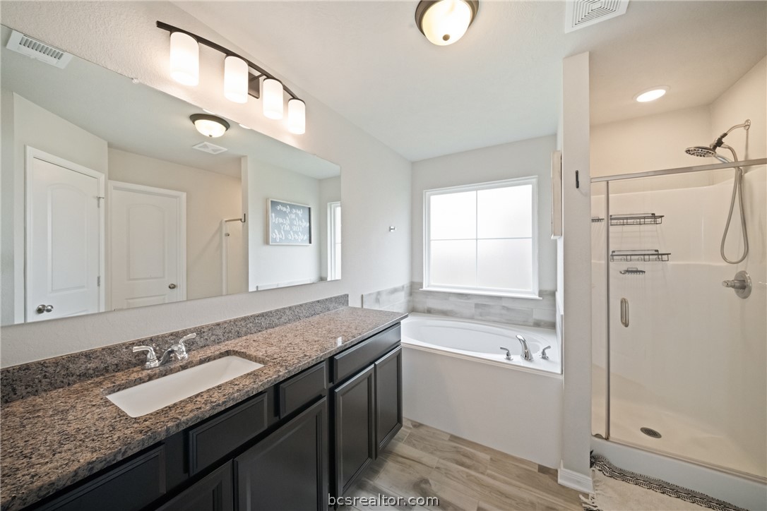 203 36th Ridge Caldwell, TX 77836 - Photo 13 of 31 a bathroom with a granite countertop bathtub a sink and a shower