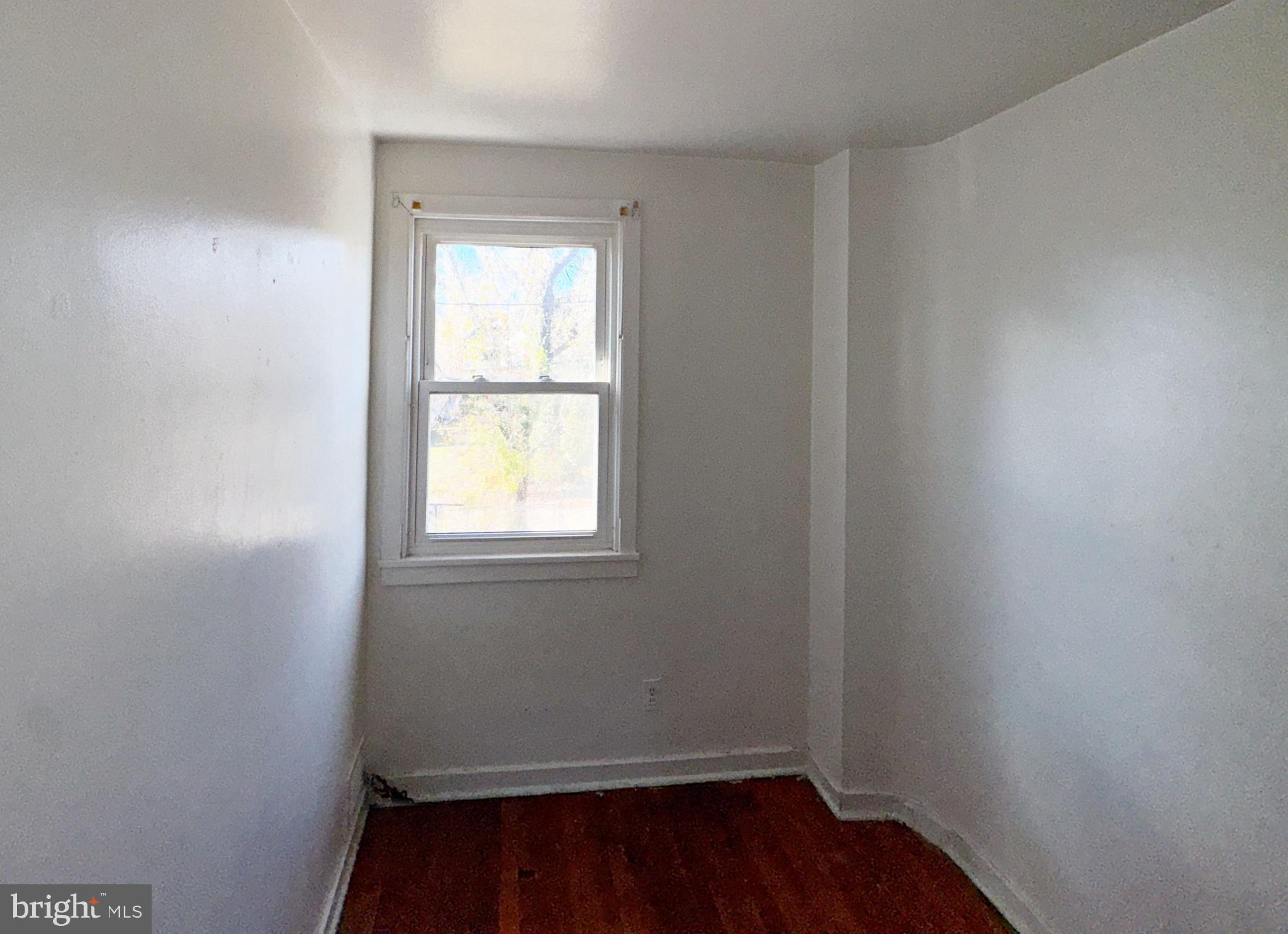 44 North Athol Avenue Baltimore, MD 21229 - Photo 16 of 18 a view of an empty room with wooden floor and a window