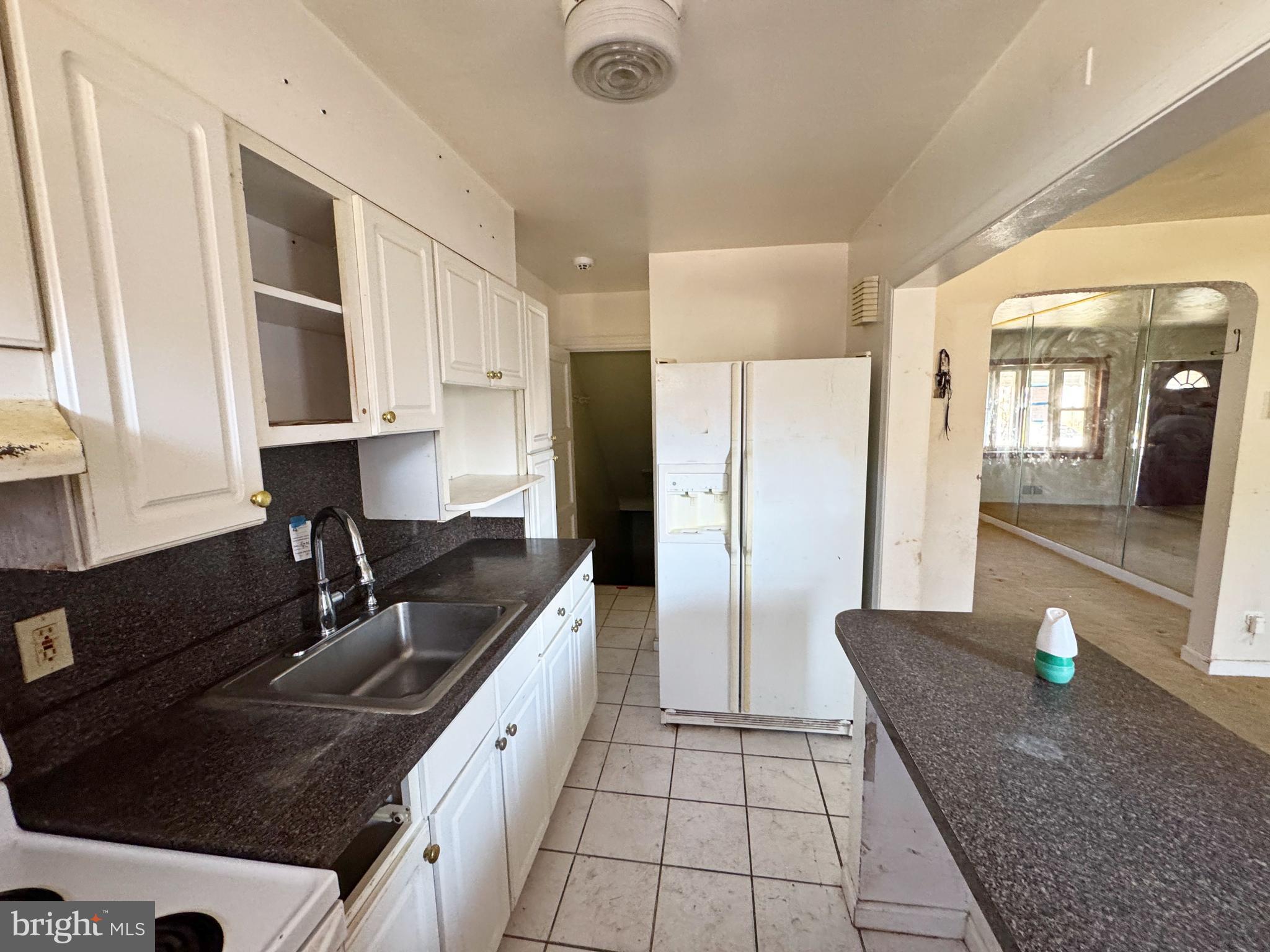 44 North Athol Avenue Baltimore, MD 21229 - Photo 10 of 18 a kitchen with granite countertop a sink a stove and a refrigerator
