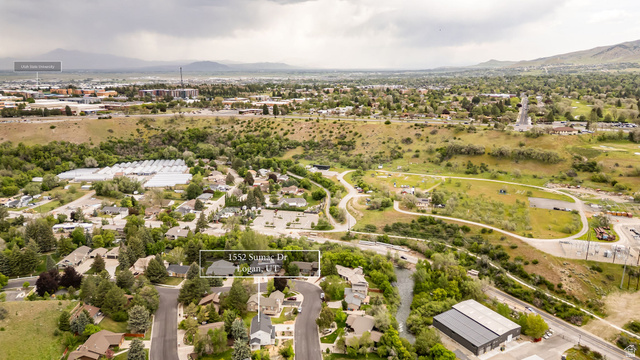 1552 Sumac Drive Logan, UT 84321 - Photo 64 of 72 Aerial perspective showcasing a residential neighborhood with surrounding green spaces and distant mountains