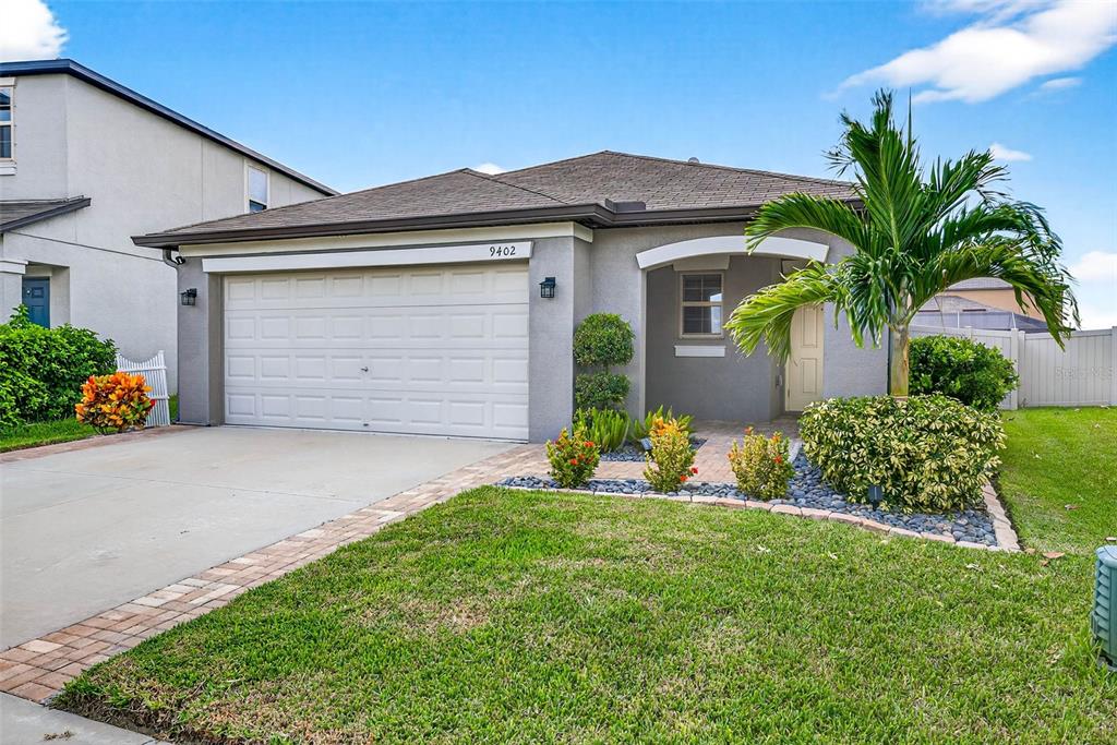 9402 Lemon Drop Loop Sun City Center, FL 33573 - Photo 1 of 1 a front view of house with yard and potted plants