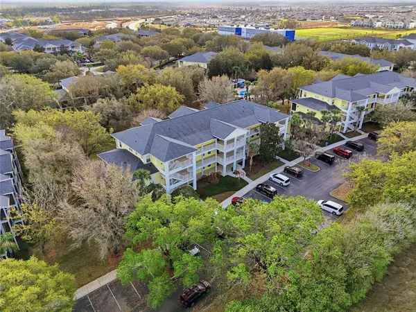 an aerial view of residential houses with outdoor space and parking