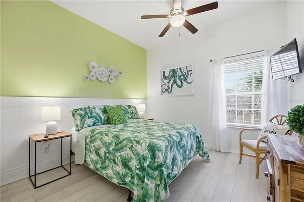 a bedroom with a bed table chair and window
