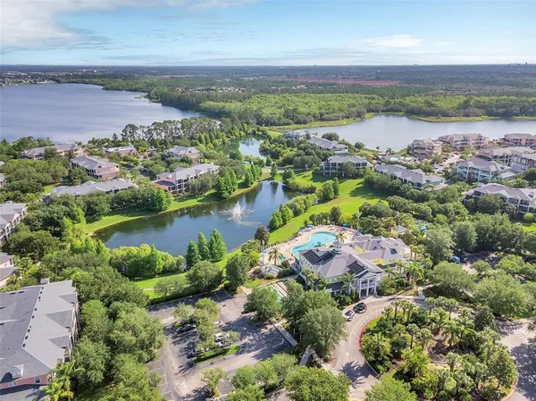 an aerial view of residential houses with outdoor space and lake view
