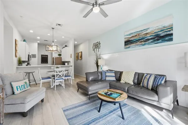 a living room with furniture kitchen view and a potted plant