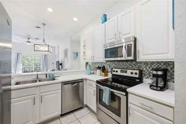 a kitchen with appliances a sink and cabinets
