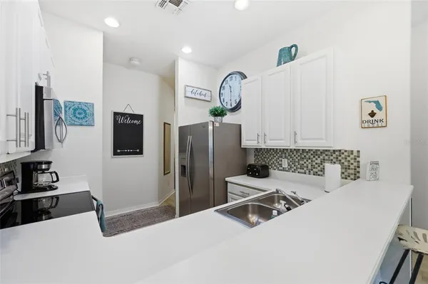 a kitchen with stainless steel appliances a refrigerator sink and microwave