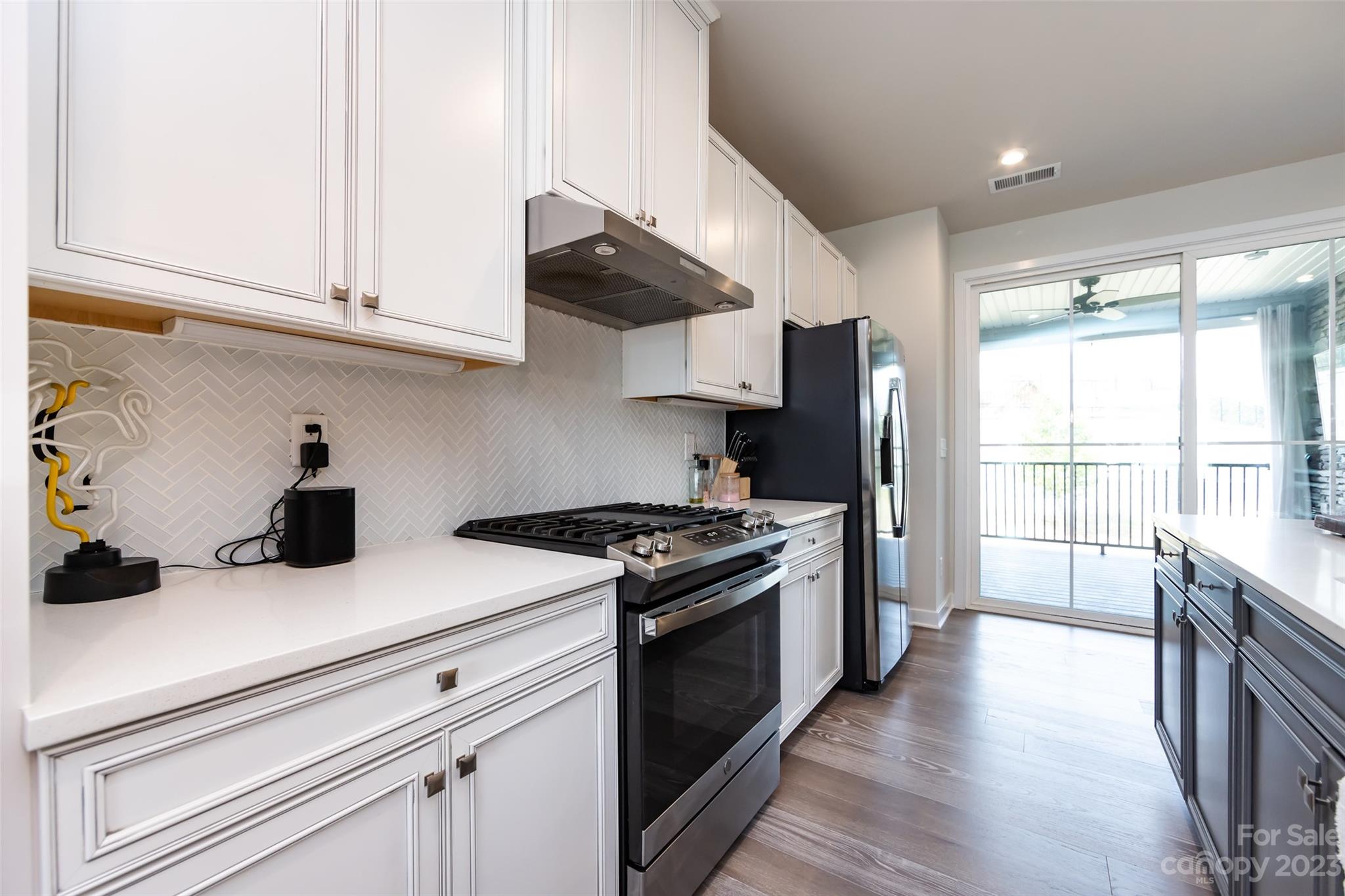 606 Crudent Road Tega Cay, SC 29708 - Photo 13 of 47 a kitchen with stainless steel appliances white cabinets and a stove top oven