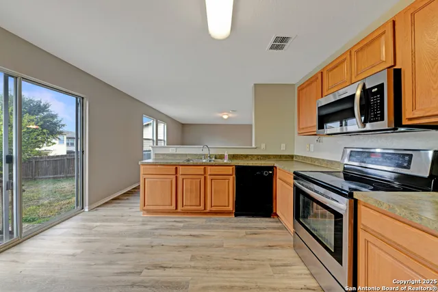 a kitchen with stainless steel appliances granite countertop a stove a sink and a microwave