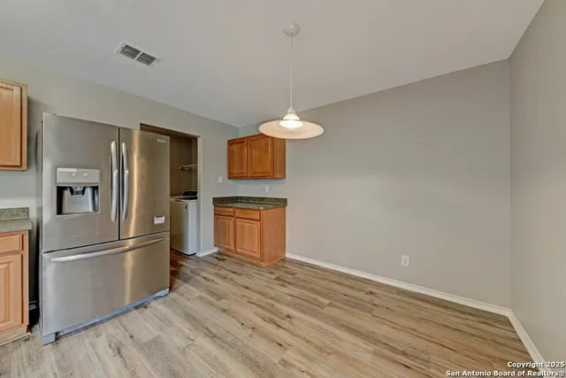 a kitchen with granite countertop a refrigerator and a sink