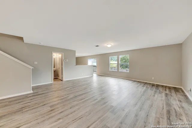 a view of empty room with wooden floor and window