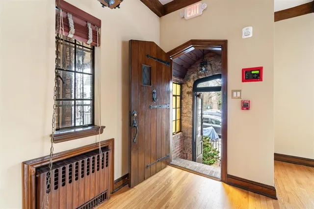 a view of a hallway with wooden floor and windows