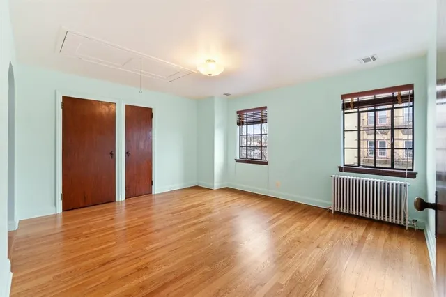 a view of empty room with wooden floor
