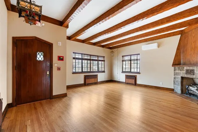 a view of empty room with wooden floor and fireplace