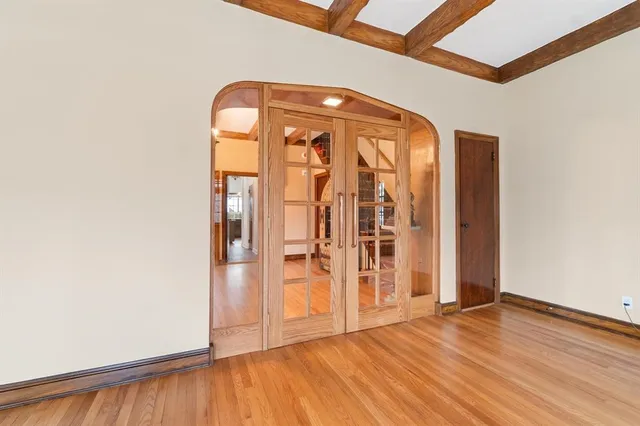 an empty room with wooden floor and entrance