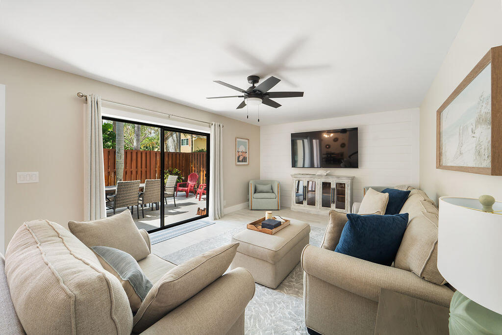 a living room with furniture ceiling fan and a window