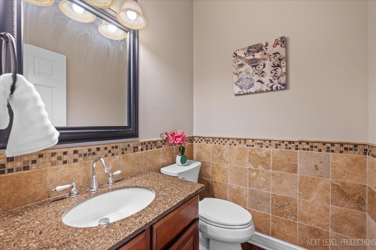 2197 Red Maple Lane Aurora, IL 60502 - Photo 19 of 48 a bathroom with a granite countertop sink a toilet a mirror and shower