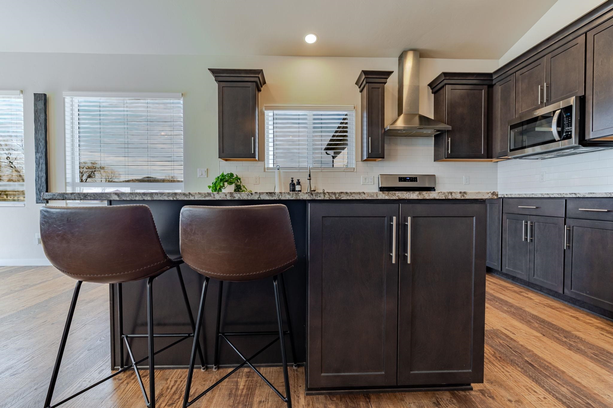 1301 M Road Loma, CO 81524 - Photo 17 of 32 a kitchen with granite countertop a sink cabinets and wooden floor