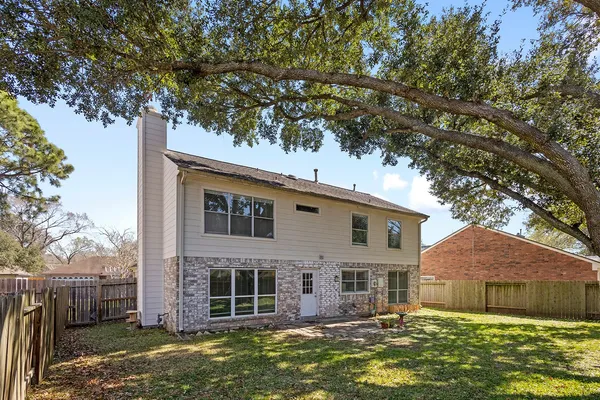 front view of a house with a large tree