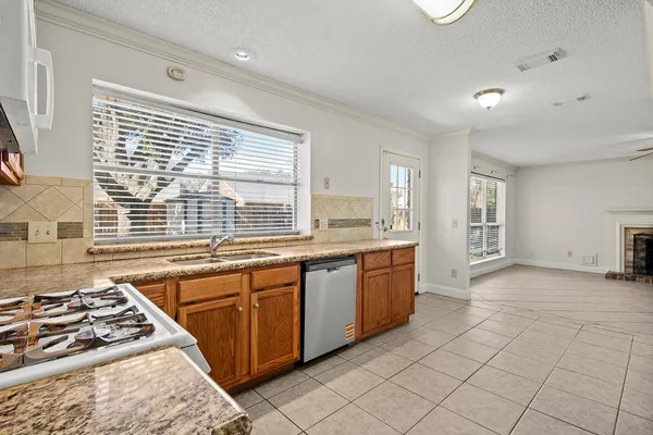 a large kitchen with stainless steel appliances granite countertop a stove a sink and a microwave