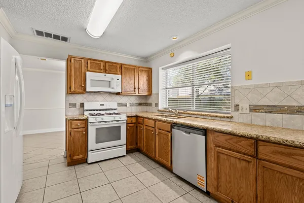 a kitchen with stainless steel appliances granite countertop a sink and stove top oven