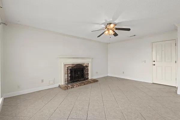 an empty room with fireplace and fan