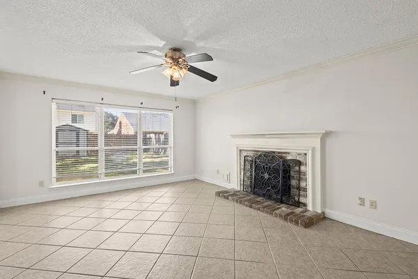 a view of an empty room with a fireplace and a window
