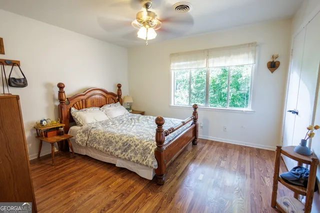 a bedroom with a bed wooden floor and window