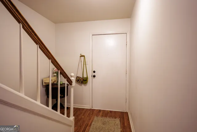 a view of hallway with wooden floor and stairs