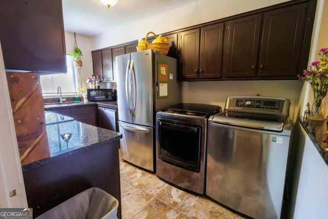 a kitchen with stainless steel appliances granite countertop a refrigerator a stove and a sink