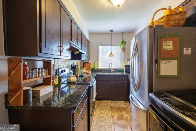a kitchen with stainless steel appliances granite countertop a refrigerator and a stove
