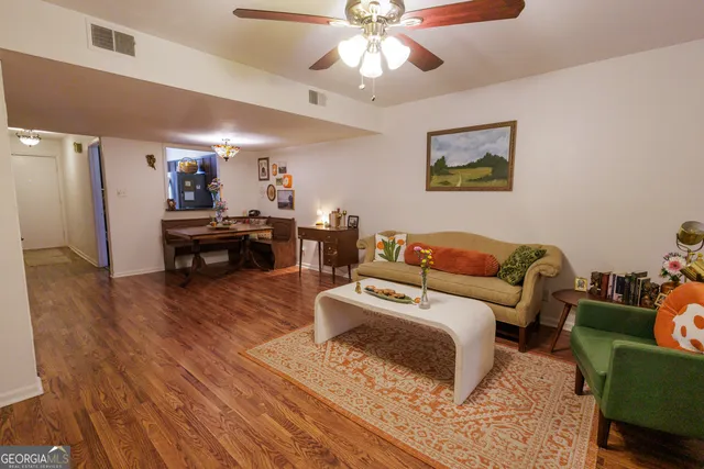 a living room with furniture and a wooden floor