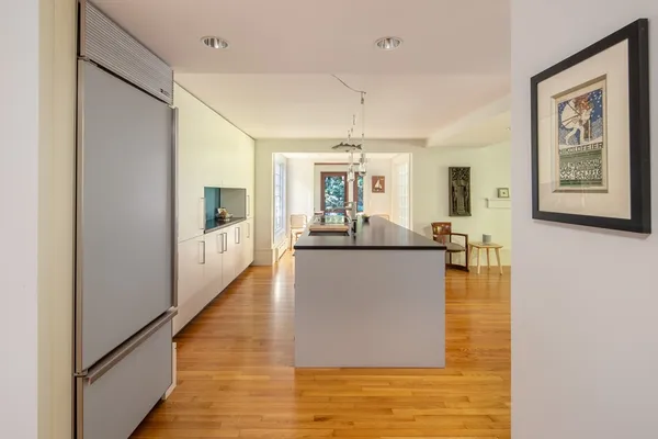 a view of a living room and kitchen with wooden floor