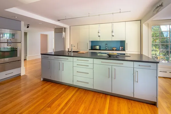 a kitchen with stainless steel appliances a sink cabinets and wooden floor
