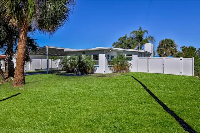 a front view of a house with a garden and trees
